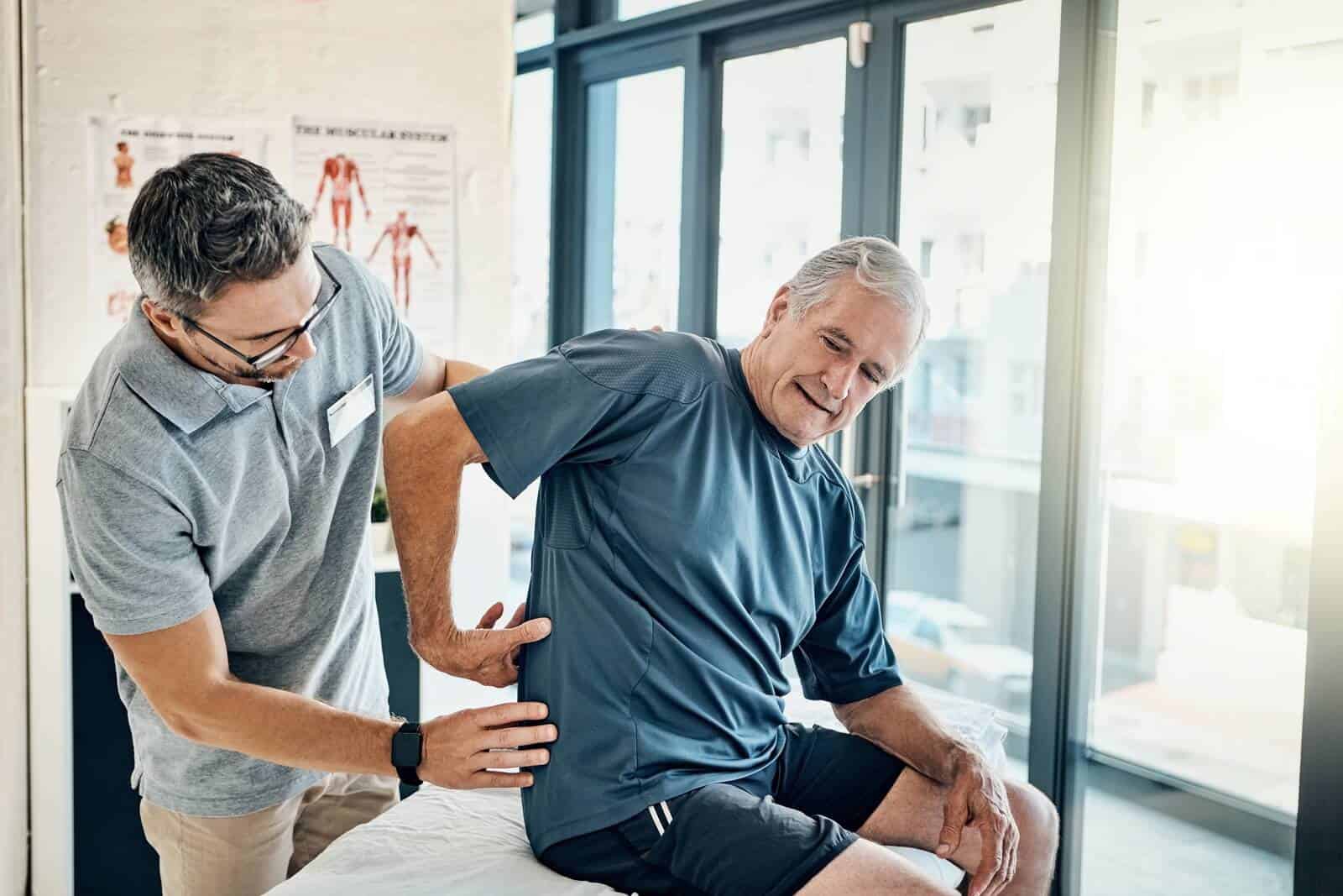 Chiropractor adjusting older man | What does a chiropractor do?