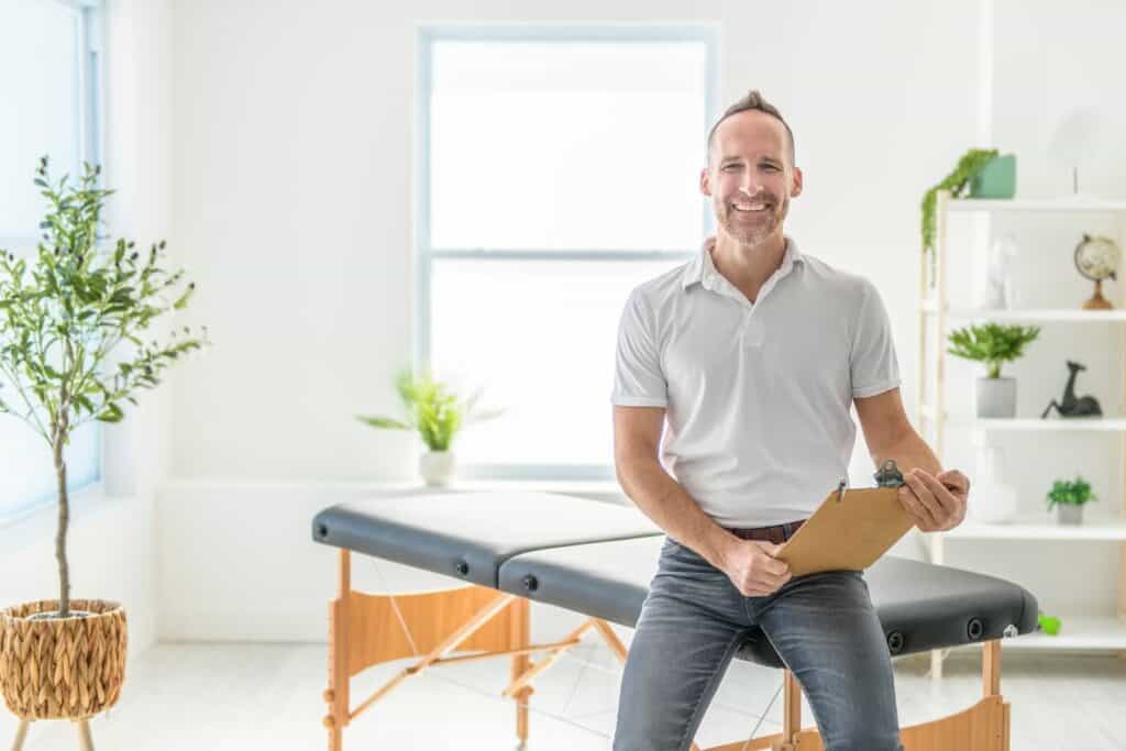 Smiling chiropractor with a clipboard  | What does a chiropractor do?