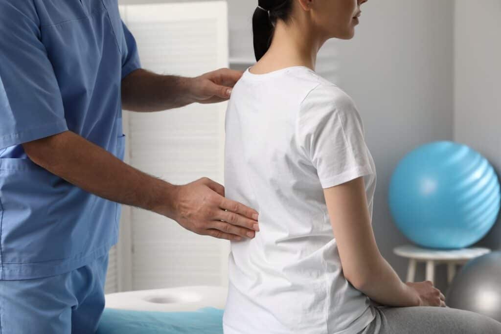 Doctor adjusting woman’s back | Ways decompression therapy can help your spine