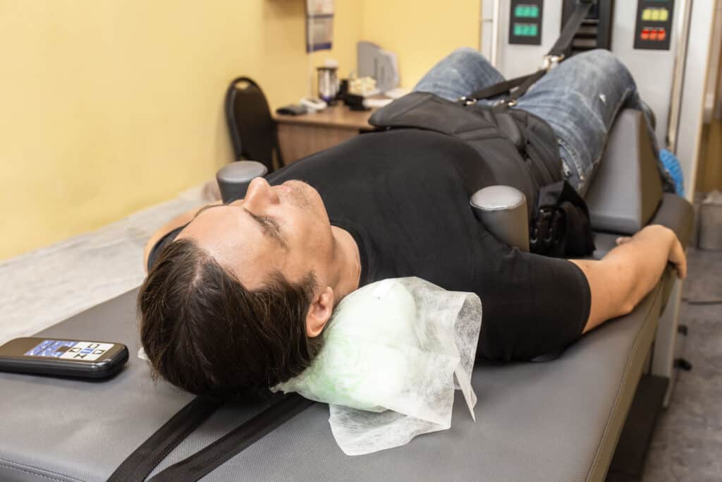 Man lying on a medical table | Ways decompression therapy can help your spine