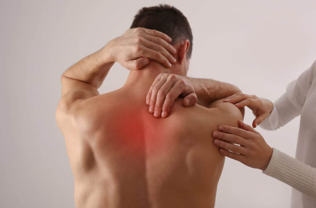 Man with red soreness on his back | Ways decompression therapy can help your spine