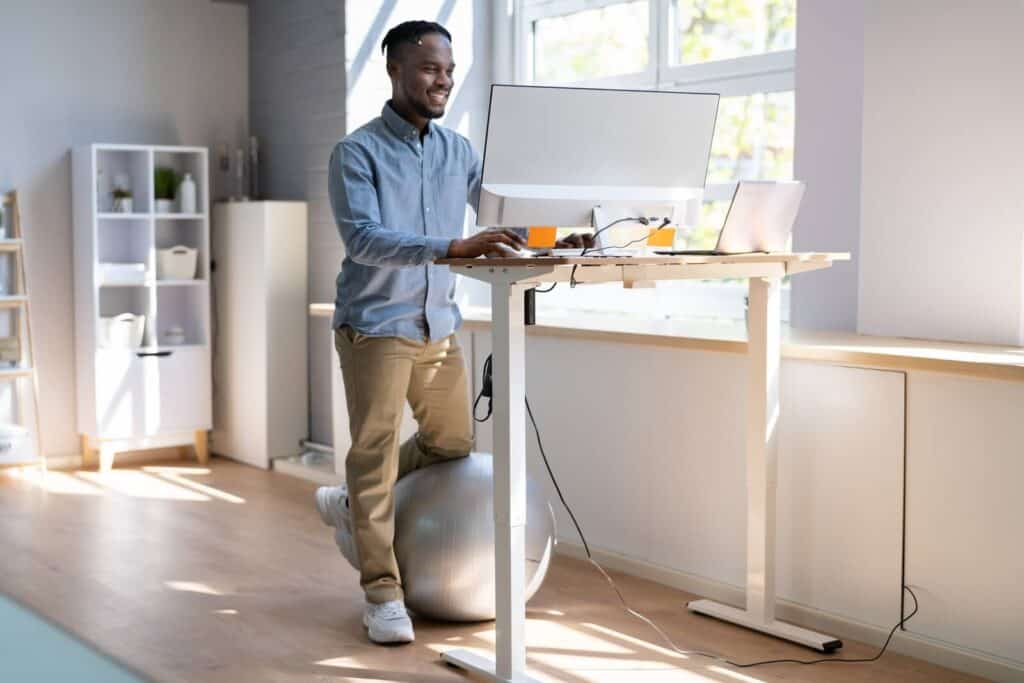 A man at a stand-up desk | Tips for getting rid of tech neck